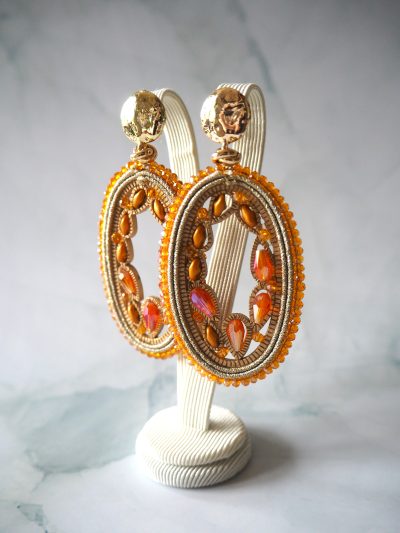 Leuke opvallende oorbellen van brass stekers met oranje kristal en gouddraad.