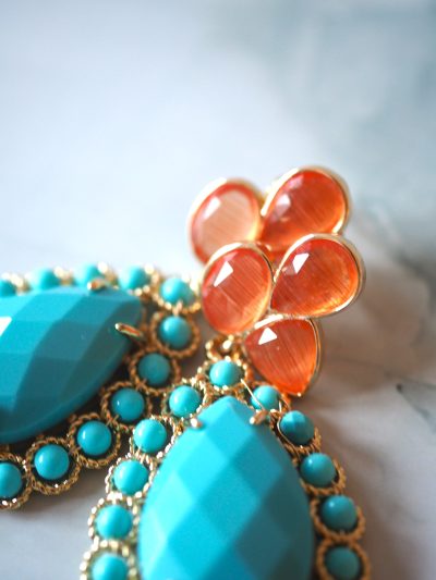 Leuke vrolijke oorbellen van brass stekers met kattenoog en turquoise in oranje en turquoise tinten.